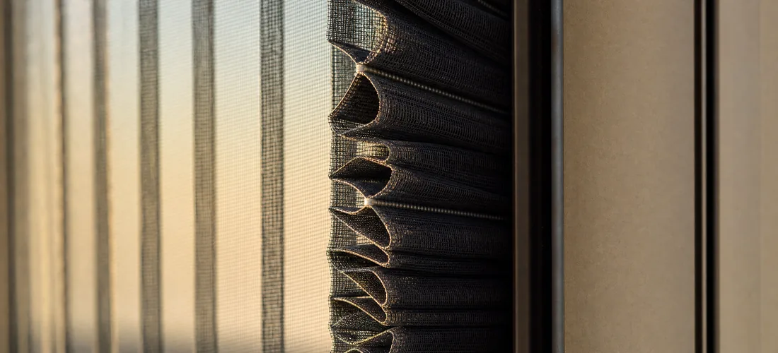 The folds of a pleated screen stacked against its side cassette