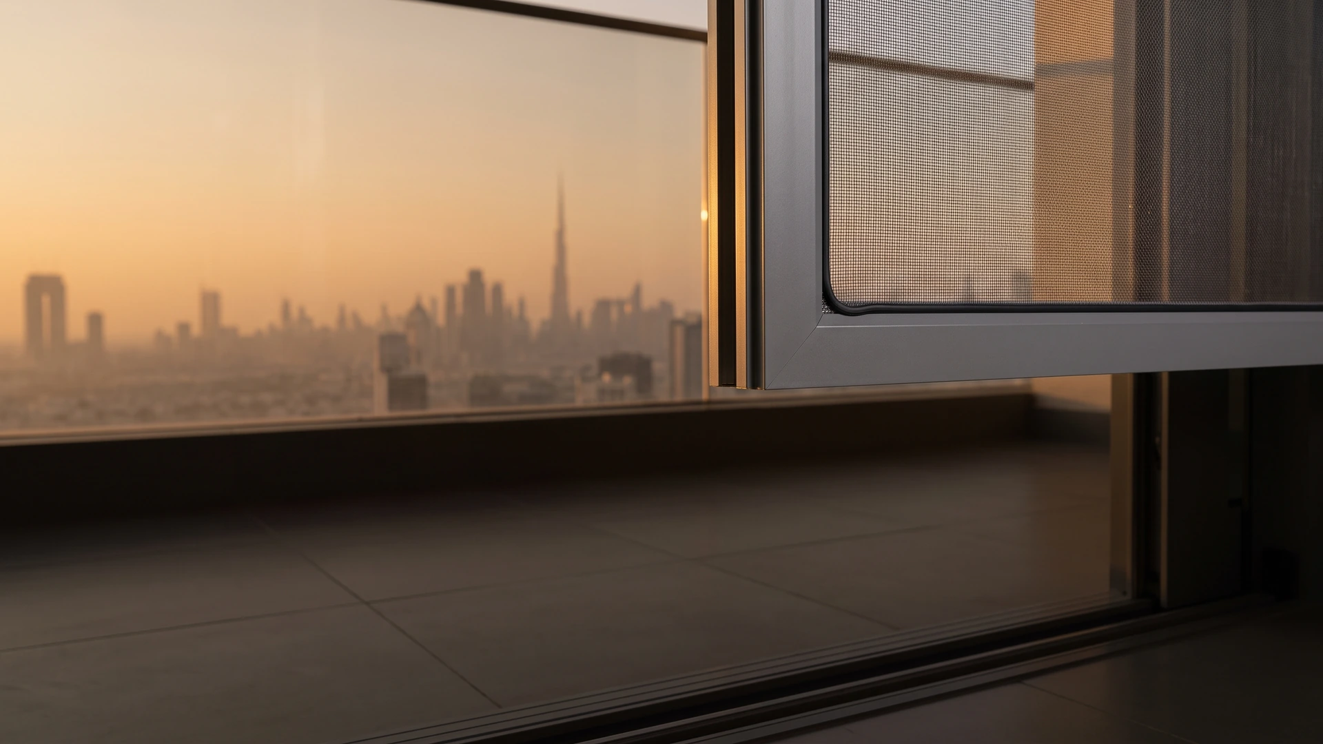 Corner of an aluminium mosquito screen frame in a balcony door opening on an upper floor of a Dubai tower