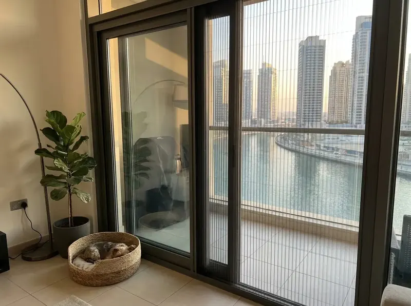 Closed pleated mosquito screen on the balcony door of a high-rise apartment