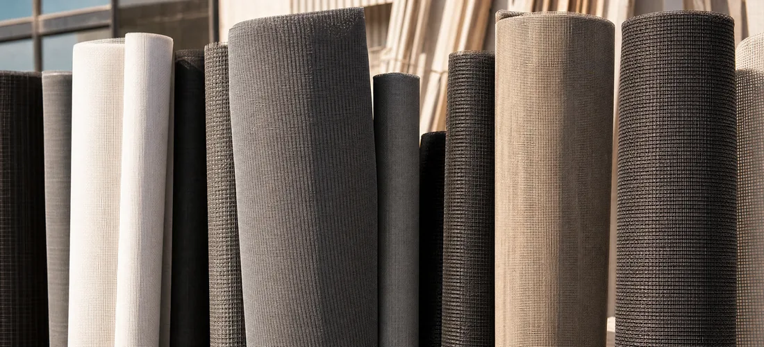 Rolls of different mesh standing side by side in a workshop