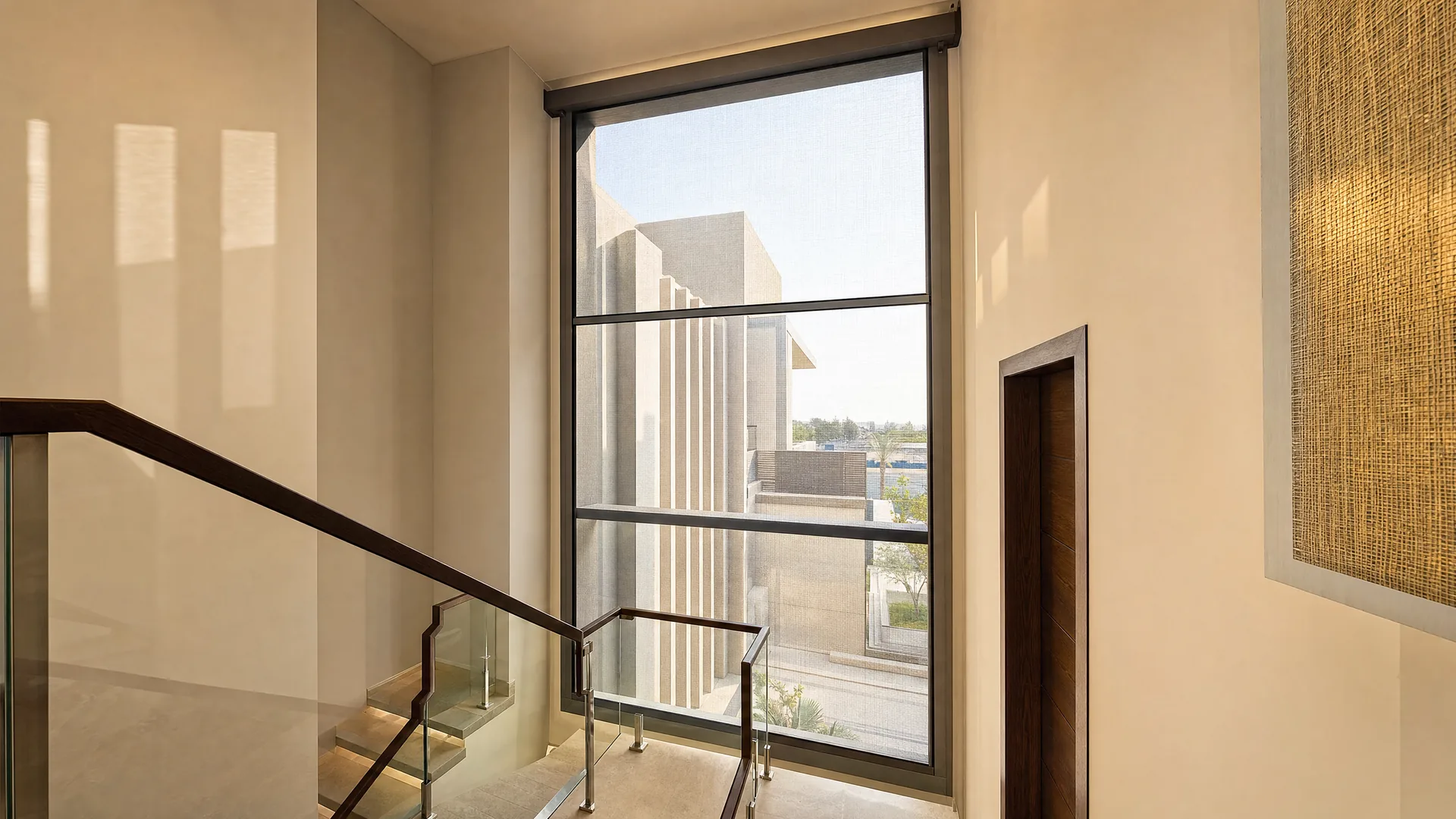 A motorised screen on a tall window above a staircase