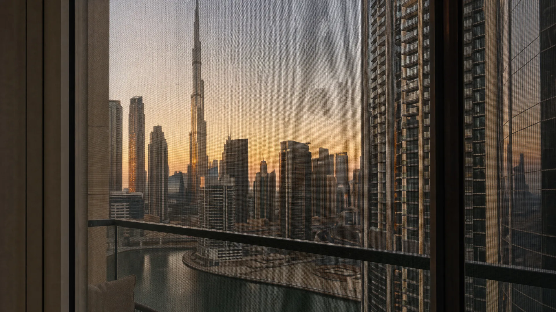 Downtown Dubai की आम इमारतें और सामने खिड़की पर लगी मच्छर जाली